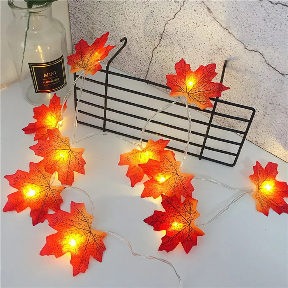 Maple Leaf LED Garland Lights – lit garland draped over a black wire rack next to a glass bottle