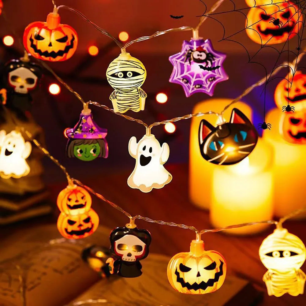 Halloween String Lights – mixed charms glowing: jack-o'-lanterns, ghosts, a mummy, a black cat and a witch