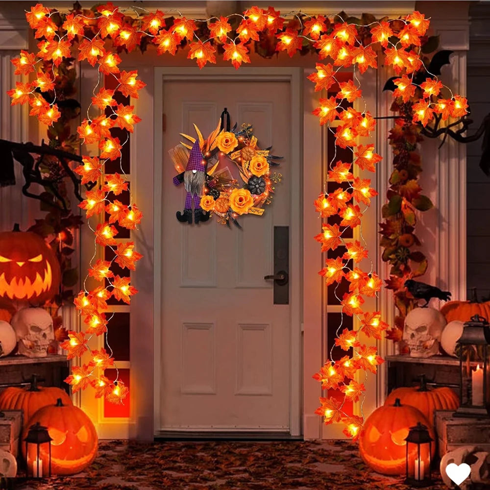 Maple Leaf LED Garland Lights – lit maple leaf garland framing a front door at night with jack-o'-lanterns and a wreath