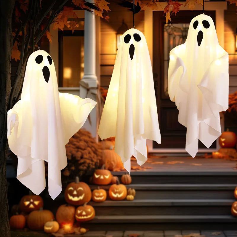 Light-Up Hanging Ghosts – three white sheet ghosts hanging on a front porch with pumpkins